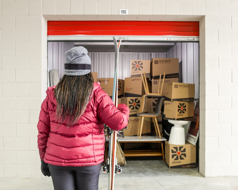 Woman holding skis in front of storage unit full of boxes at StorQuest Self Storage in Santa Monica, California