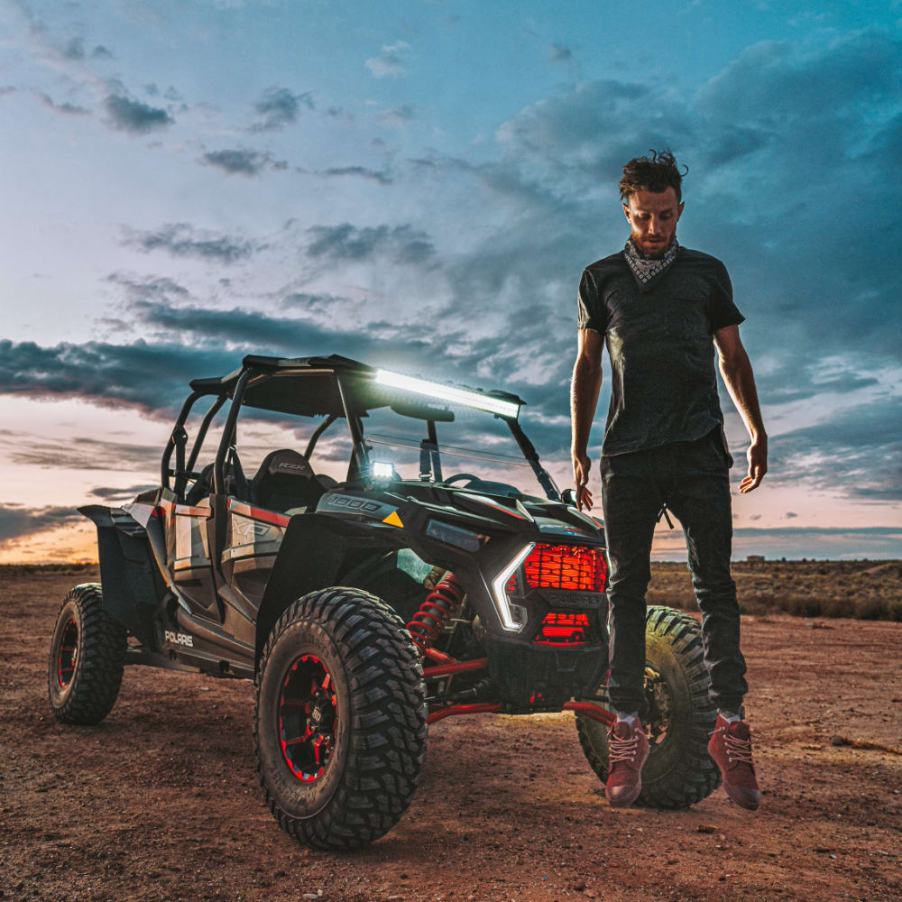 StorQuest Self Storage guest and Adventure Squad leader, Jordan Kahana, in front of an ATV in the desert